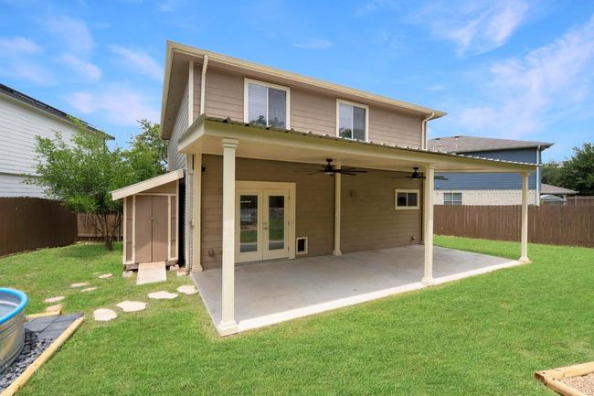 Rear view of house featuring french doors, a fenced backyard, ceiling fan, a patio, and a shed | Image 30