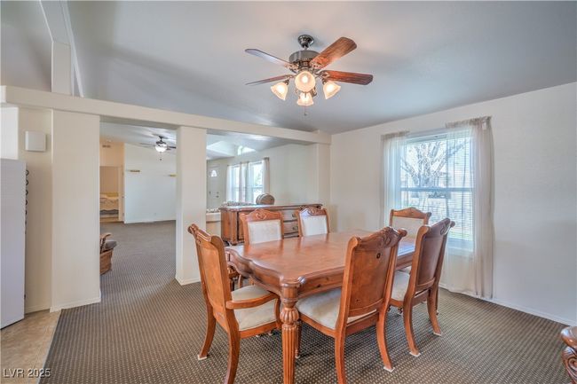 Dining room featuring a ceiling fan, light carpet, and baseboards | Image 12