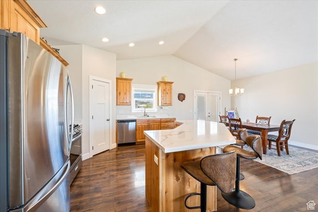 Kitchen with lofted ceiling, a kitchen island, appliances with stainless steel finishes, and dark wood finished floors | Image 14