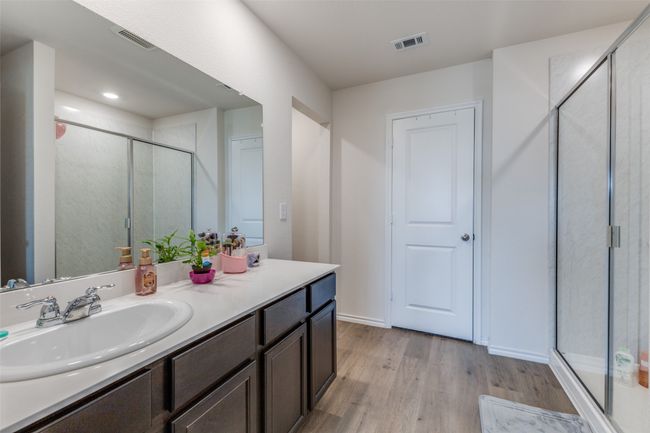 Full bath featuring visible vents, a stall shower, vanity, and wood finished floors | Image 14