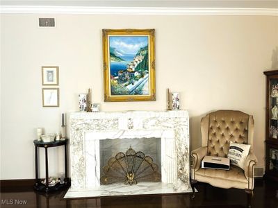 Living room with dark hardwood / wood-style flooring, a premium fireplace, and crown molding | Image 3