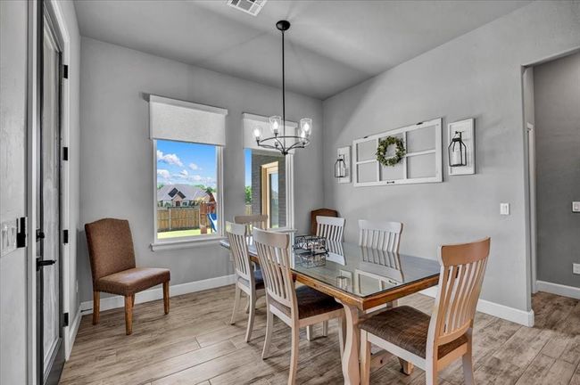 Dining space featuring light wood-style floors, a chandelier, and baseboards | Image 21