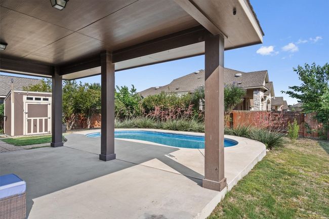 View of swimming pool with a patio area and a fenced backyard | Image 24