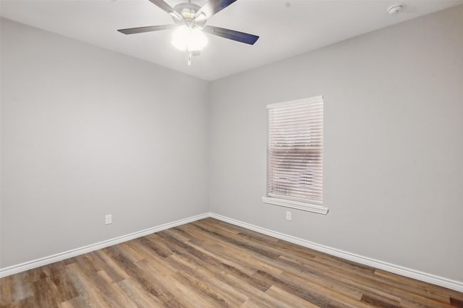 Spare room with baseboards, wood finished floors, and ceiling fan | Image 23