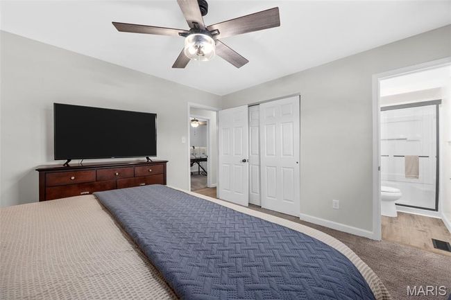 Bedroom featuring light carpet, ensuite bath, a closet, and ceiling fan | Image 19