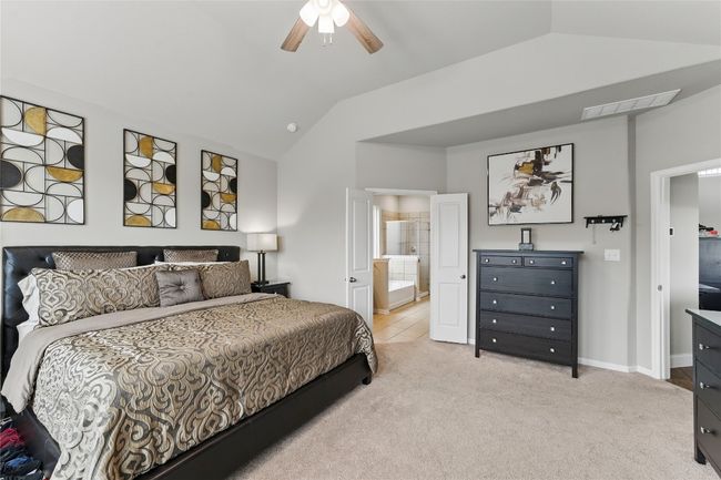 Bedroom with lofted ceiling, baseboards, visible vents, ceiling fan, and light colored carpet | Image 21