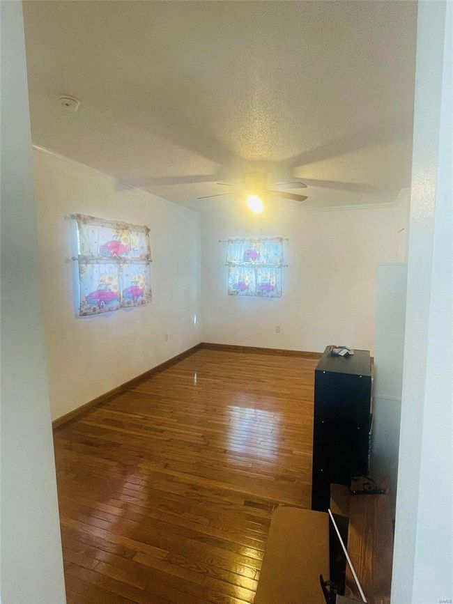 Spare room featuring hardwood / wood-style floors, a textured ceiling, ceiling fan, and baseboards | Image 5