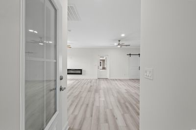 Corridor featuring light hardwood / wood-style floors and a barn door | Image 3