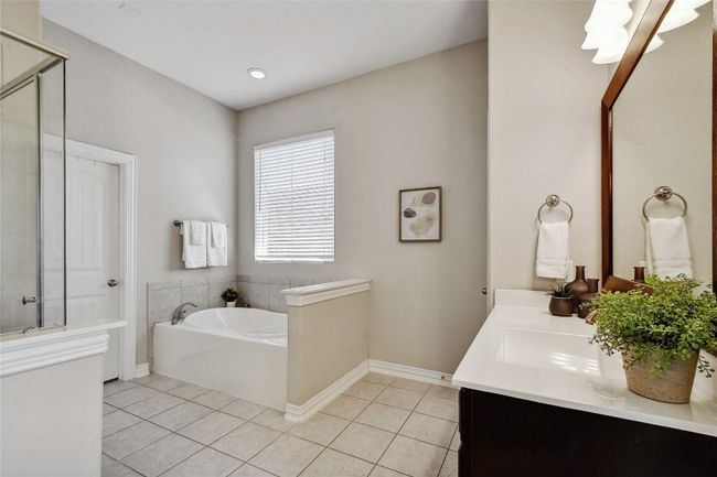 The luxurious en-suite bathroom features 2 separate vanities, a garden tub, and a walk-in shower. | Image 21