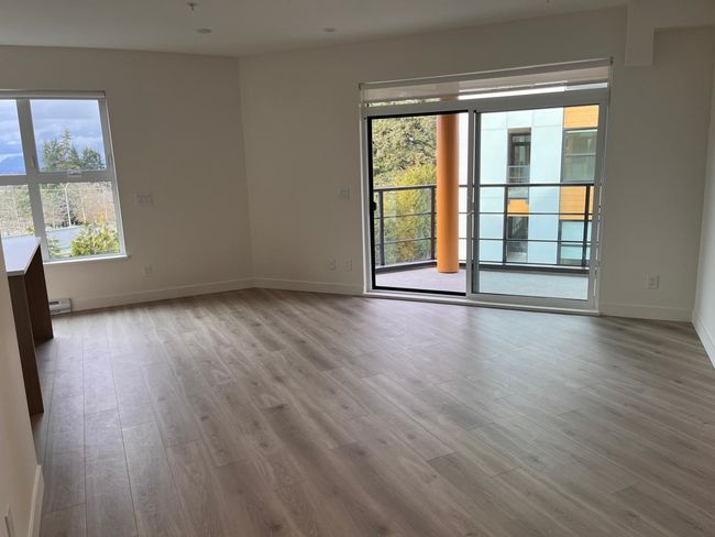 Spare room featuring plenty of natural light, wood finished floors, and baseboard heating | Image 10