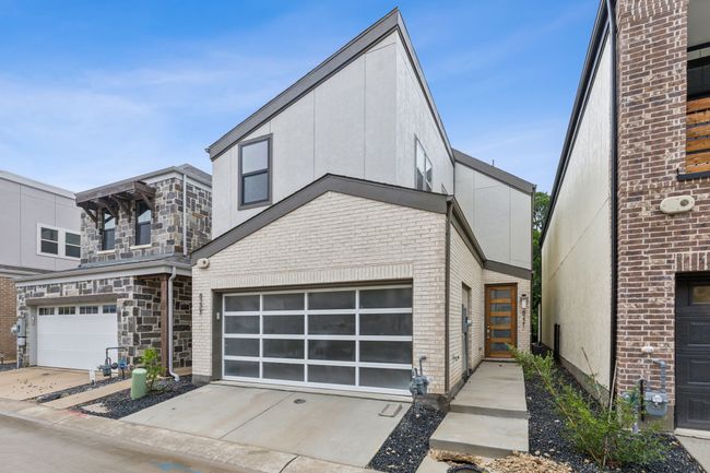 Modern home with a garage, concrete driveway, stucco siding, and brick siding | Image 4