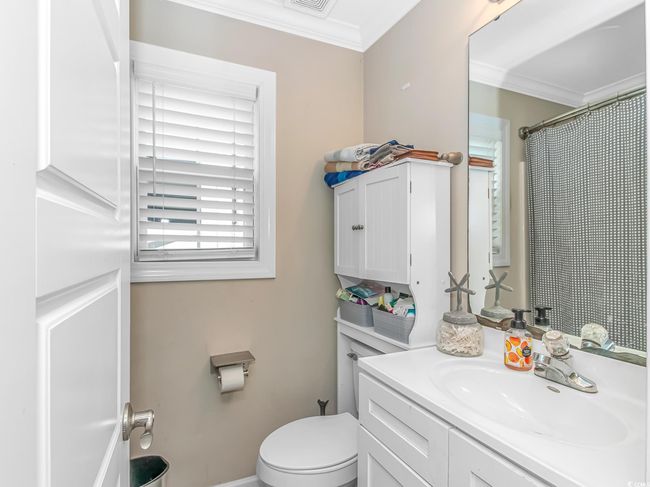 Bathroom with crown molding, toilet, vanity, and curtained shower | Image 18