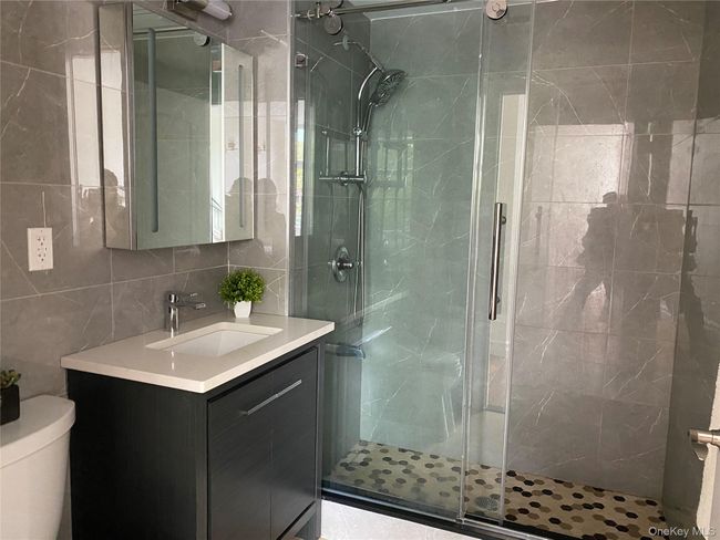 Full bathroom with tile walls, vanity, a stall shower, and tasteful backsplash | Image 13