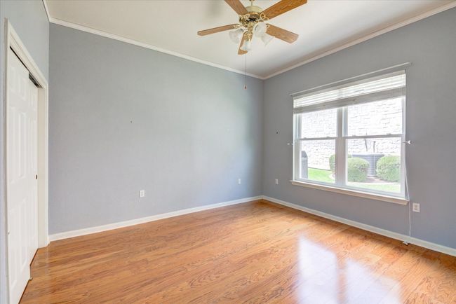 Unfurnished bedroom 2 featuring light wood finished floors, crown molding, a ceiling fan, and a closet | Image 20