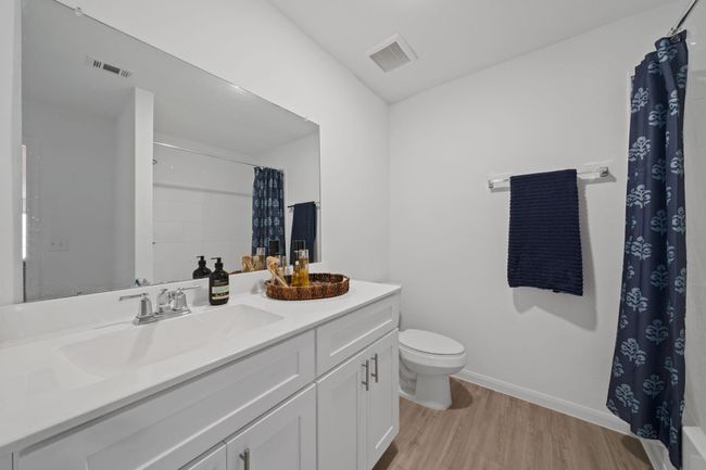Stylish full bath showcases durable LVP flooring and cabinetry with modern hardware for a clean, updated look. | Image 21