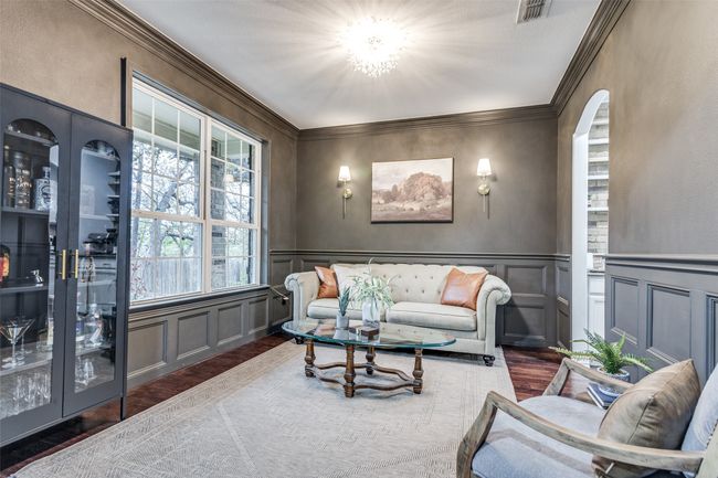 Living area featuring a decorative wall, ornamental molding, arched walkways, wood finished floors, and wainscoting | Image 7