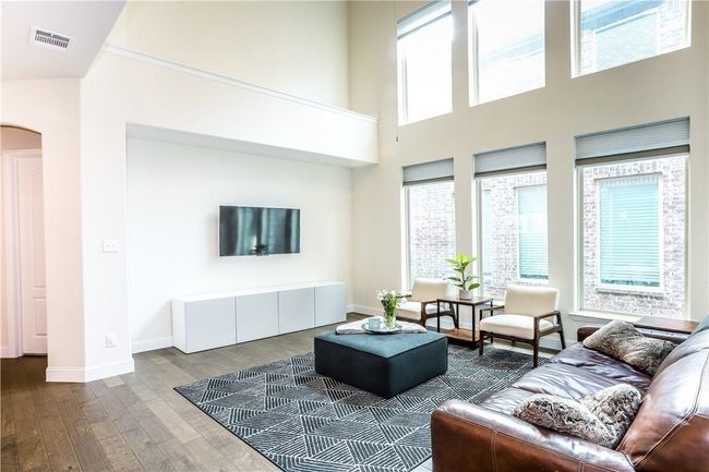 Living room featuring arched walkways, dark wood-style flooring, and a towering ceiling | Image 8