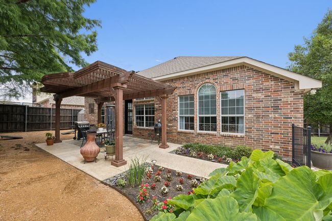 Directly off the family room, this courtyard area delivers a casual play space tucked beneath mature shade trees—ideal for yard games, gardening, or simply relaxing in privacy. | Image 30