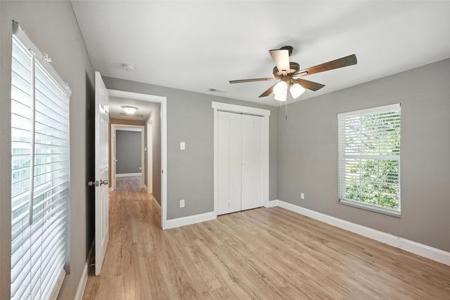 Unfurnished bedroom with light wood-style floors, multiple windows, a closet, and ceiling fan | Image 9
