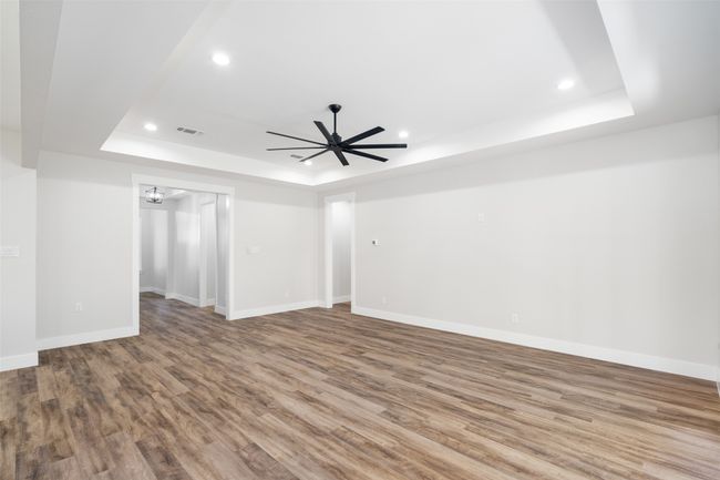 Spare room featuring hardwood / wood-style flooring, a raised ceiling, and ceiling fan | Image 11