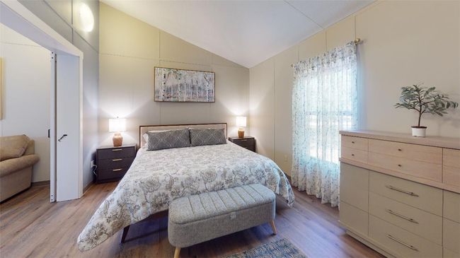 Bedroom with light wood-style floors and lofted ceiling | Image 41