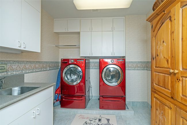 Laundry area featuring cabinets, separate washer and dryer, and sink | Image 25