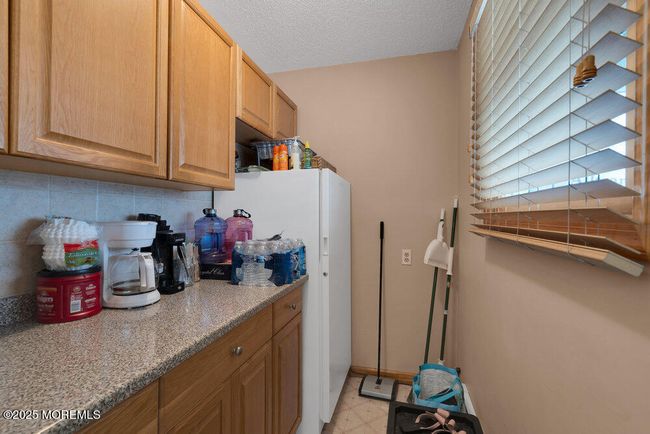 Extra storage space in the room off the front entry, which has more cabinetry and an extra fridge | Image 25