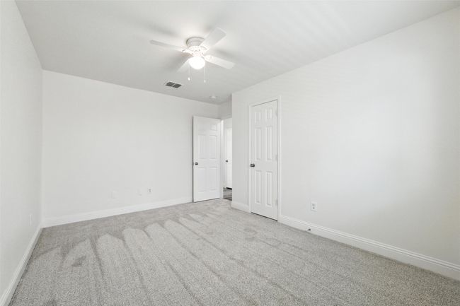 Carpeted empty room featuring a ceiling fan and baseboards | Image 15