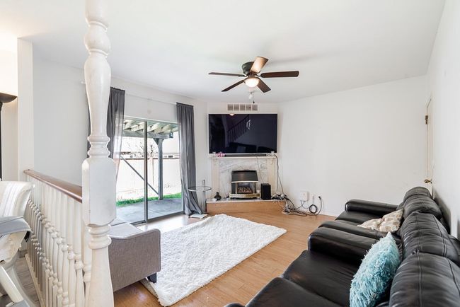 Living room with visible vents, a ceiling fan, and wood finished floors | Image 4