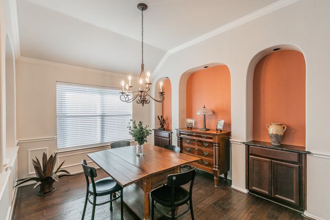 Dining space with dark wood finished floors, vaulted ceiling, a notable chandelier, and ornamental molding | Image 4