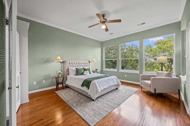 The primary bedroom features original hardwood floors and a wall of north-facing windows with serene tree-filled views. Spacious enough for a king bed, nightstands, and more. | Image 23