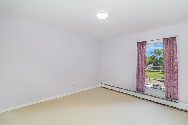 The second bedroom features a large window | Image 11