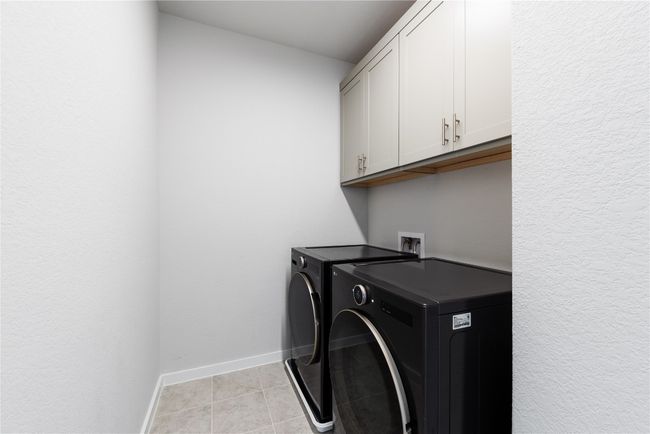 Laundry room with baseboards, cabinet space, independent washer and dryer, and light tile patterned floors | Image 21