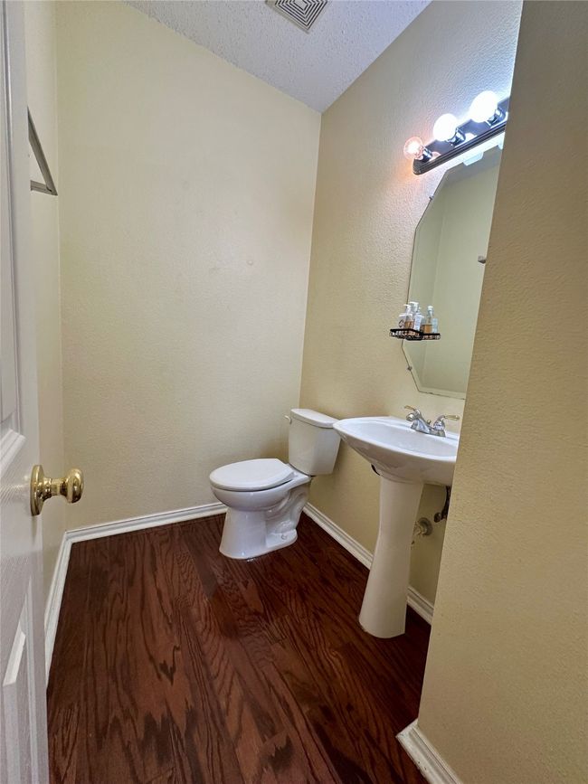 Half bath with wood finished floors and a textured ceiling | Image 15