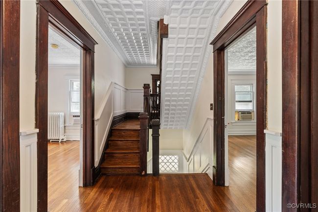 Stairway with radiator heating unit, a decorative wall, hardwood flooring, crown molding | Image 42