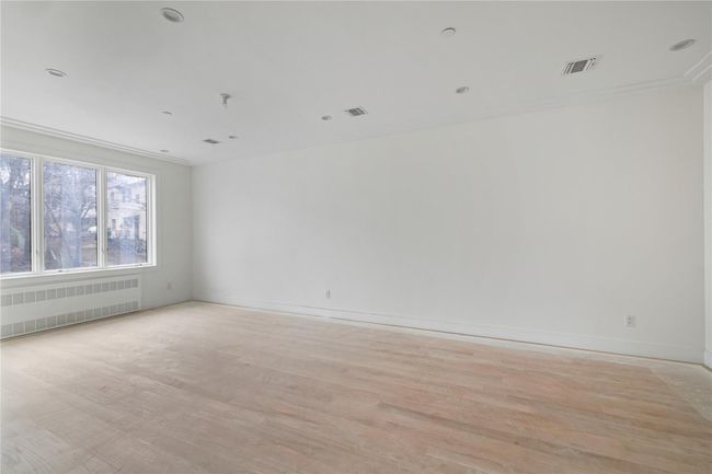 Unfurnished room with radiator heating unit, baseboards, visible vents, and light wood finished floors | Image 10