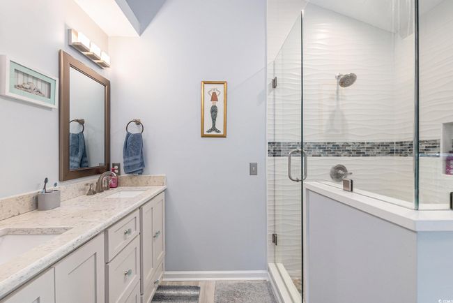 Full bathroom featuring a shower stall, double vanity, and baseboards | Image 22