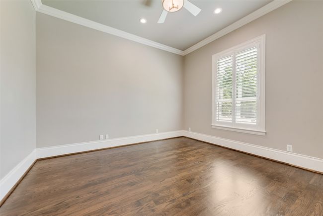 Empty room with a ceiling fan, crown molding, baseboards, dark wood-style floors, and recessed lighting | Image 19