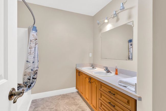 Bathroom featuring double vanity, a sink, and baseboards | Image 24