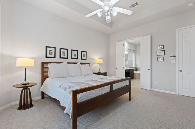 Bedroom with light carpet, baseboards, and ensuite bath | Image 11