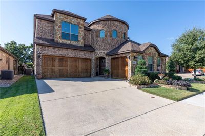 View of front of house featuring central AC unit, a front yard, and a garage | Image 2