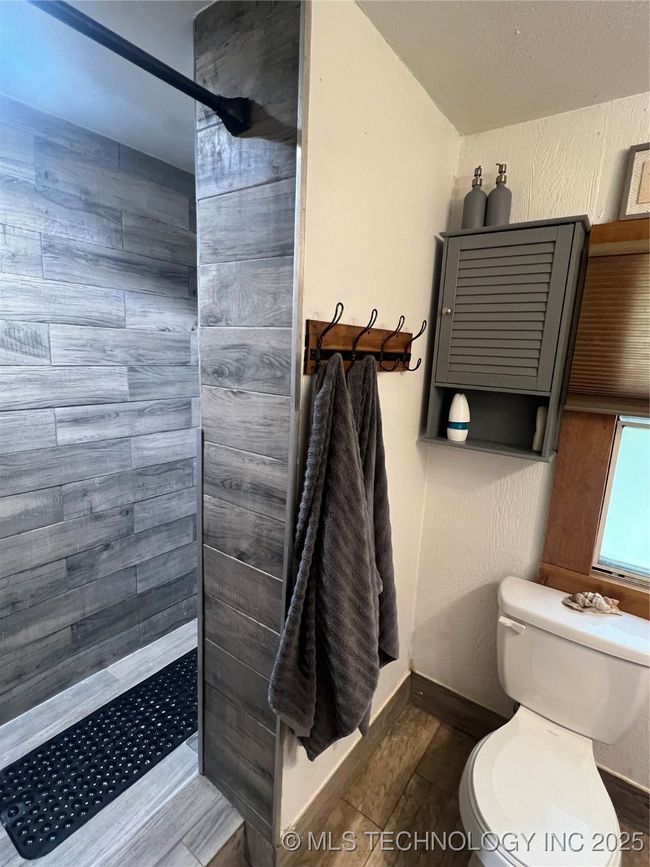 Full bath with tiled shower, toilet, and baseboards | Image 15