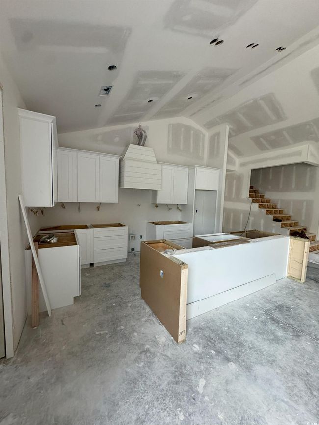 Kitchen with lofted ceiling and white cabinets | Image 21