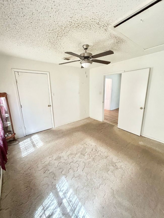 Carpeted spare room featuring ceiling fan, a textured ceiling, and attic access | Image 15