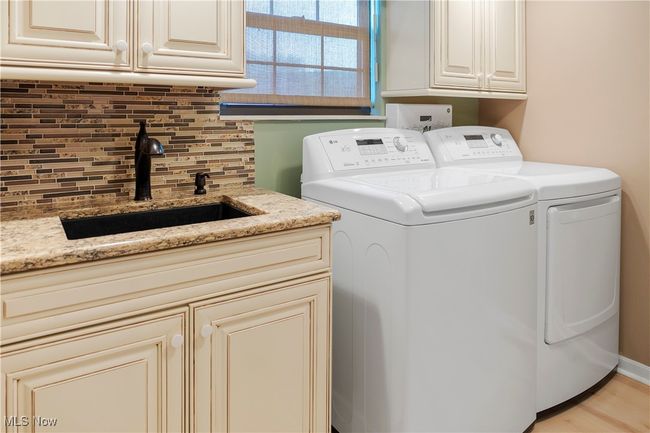 Laundry area with washing machine and dryer, a sink, and cabinet space | Image 13