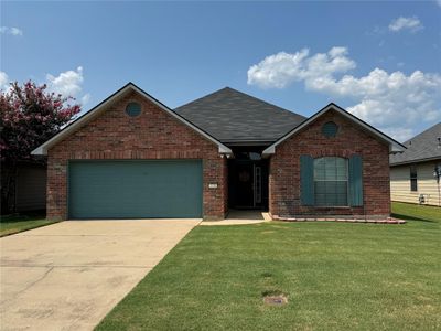 View of front facade with a garage and a front yard | Image 1