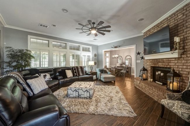 Living area with ornamental molding, visible vents, a ceiling fan, and wood tiled floor | Image 9