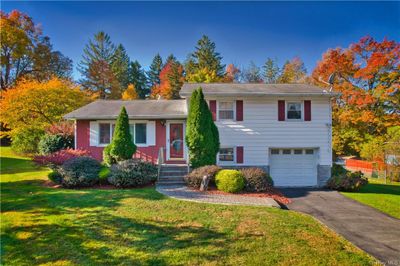 Tri-level home featuring a front yard and a garage | Image 1