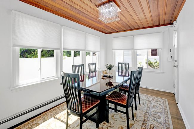 Dining area with baseboard heating, wood ceiling, healthy amount of natural light, wood finished floors, and baseboards | Image 10
