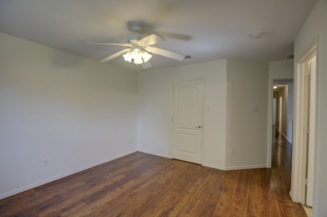 Unfurnished bedroom featuring dark wood finished floors, baseboards, and ceiling fan | Image 27